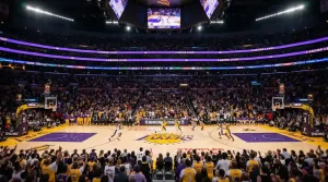 Vista panorámica de una arena NBA durante un partido de máxima audiencia con aficionados llenando las gradas y jugadores en acción